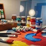 Colorful acrylic paints, paintbrushes, and acrylic sheets arranged on a canvas, representing Akrylika art materials and creative techniques.
